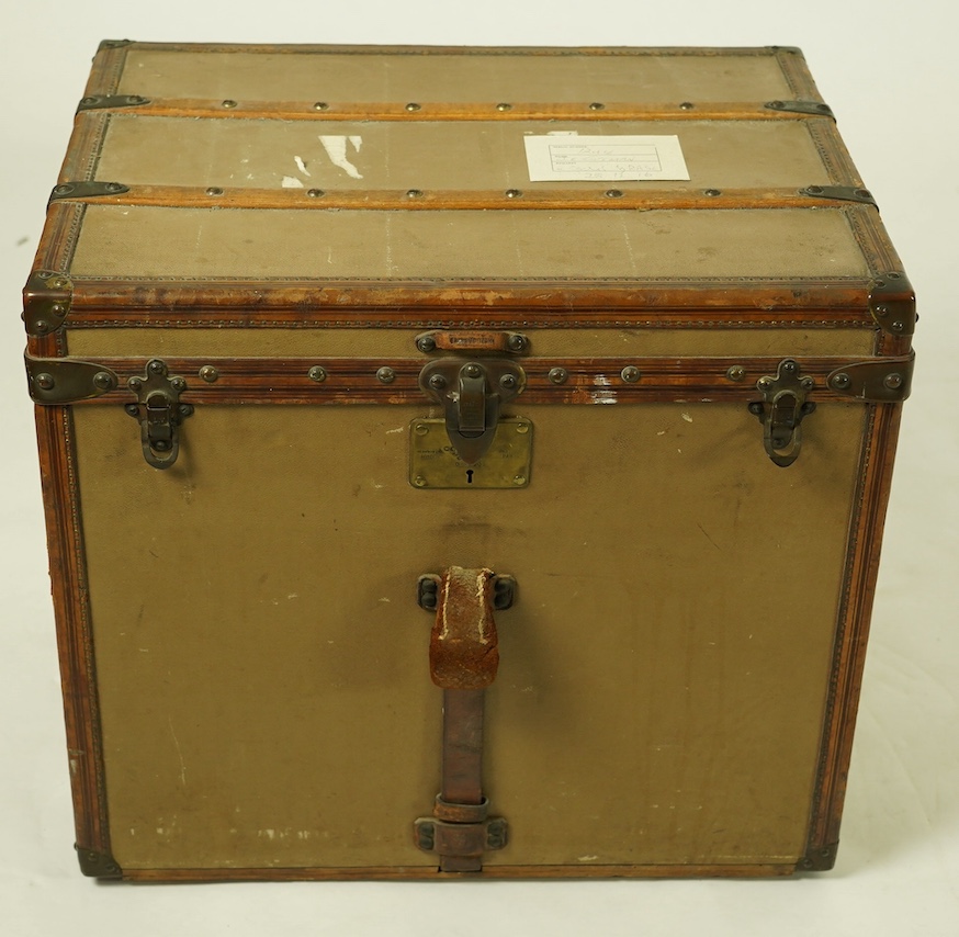 A vintage Louis Vuitton trunk, with brass and leather mounts and studded wooden slats, in plain beige canvas, with label for Paris and London, number 159008, 61cm wide, 48cm deep, 53cm high